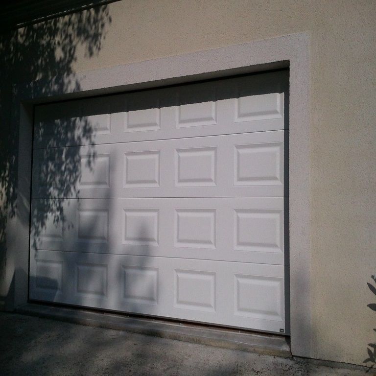 Porte de garage sectionnelle blanche pour une maison.